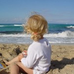 young girl sitting on beach in majorca