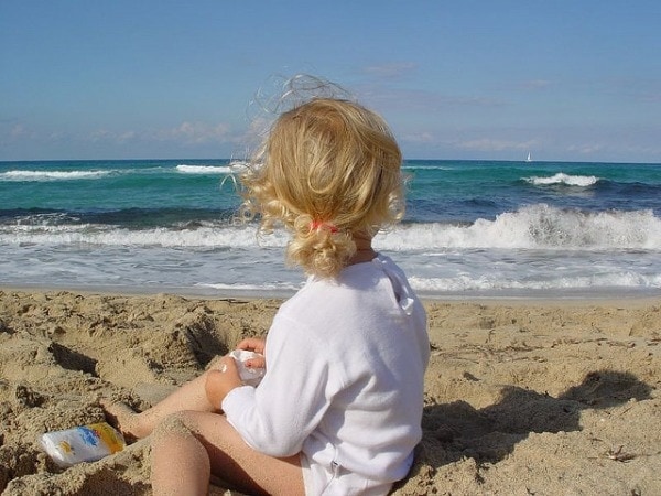 young girl sitting on beach in majorca