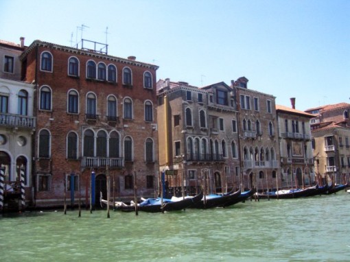 Covered gondolas in front of homes in Venice Italy