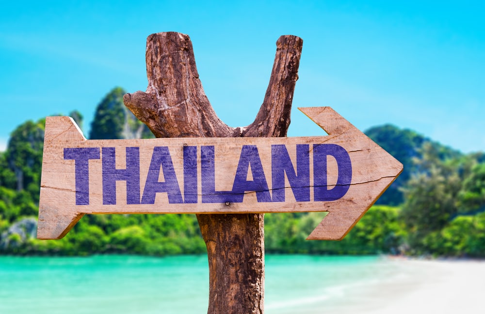 A wooden arrow sign that says Thailand