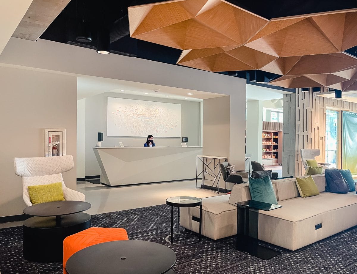 a hotel lobby with front desk clerk standing behind desk