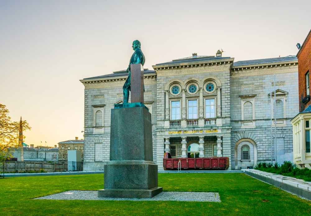 sunset view of the national gallery of ireland in dublin with statue of george bernard shaw in the front