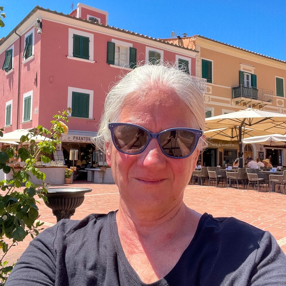 a woman standing in a square with restaurants surrounding it