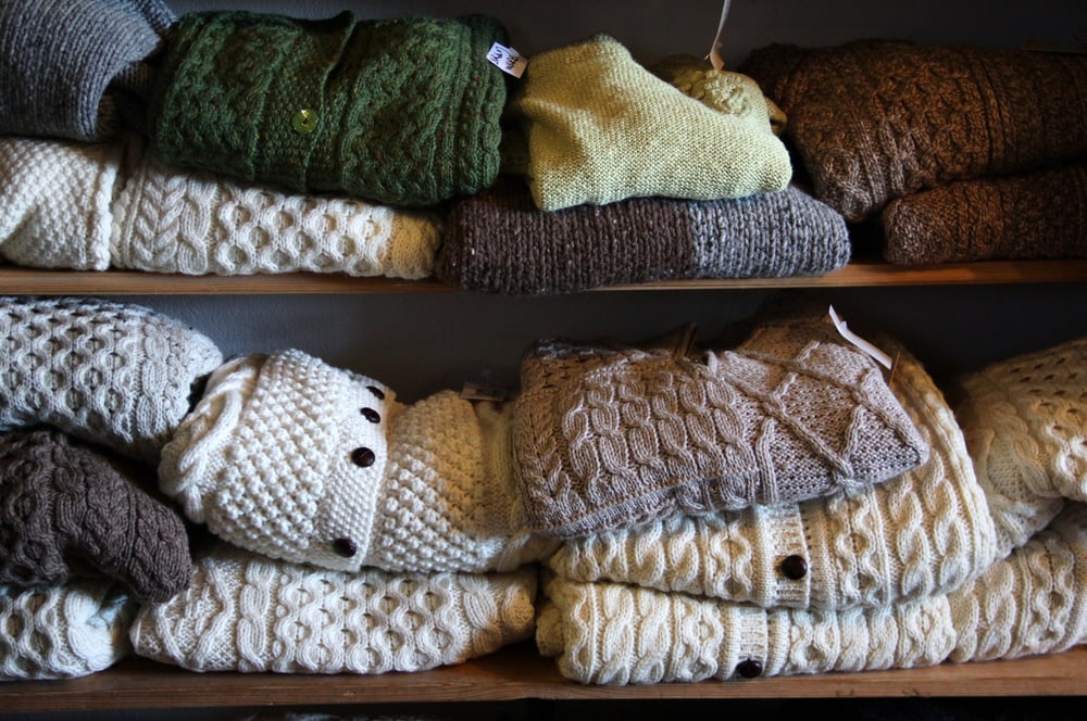 a stack of aran wool sweaters on a shelf