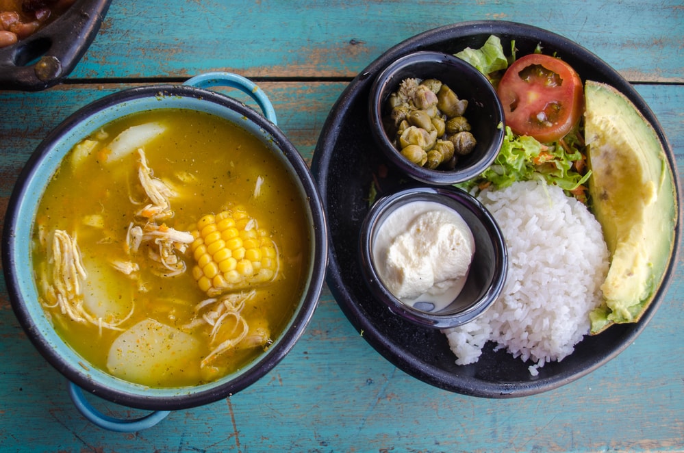 Ajiaco - A traditional colombian soup of chicken, pototoes and corn garnished with capers, avacodo and cream