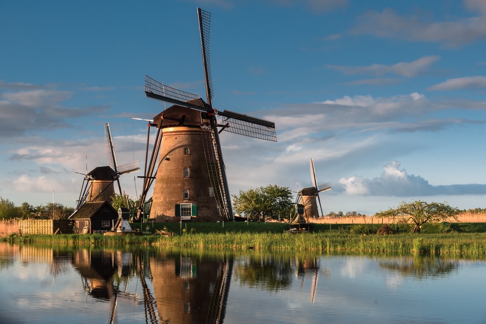 three windmills along the canals at kinderdijk, a unesco world heritage site in the netherlands