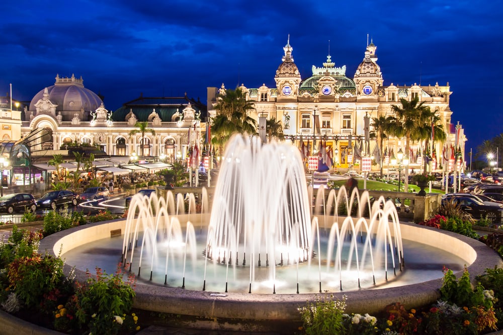 night photo of the famous monte carlo casino with fountain in front