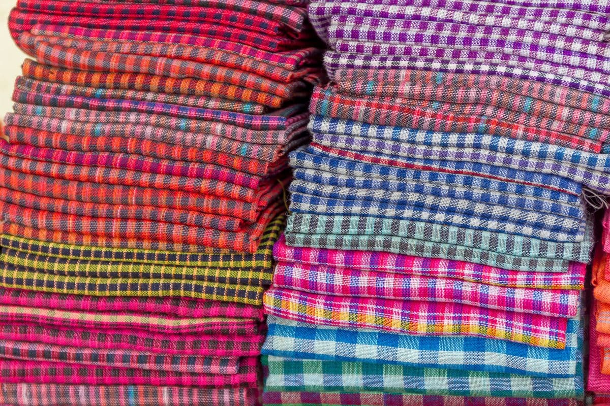 Colorful cambodian krama scarves stacked in a pile.