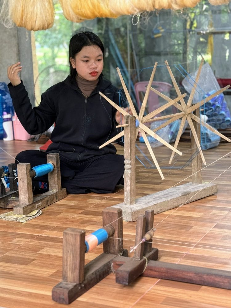 A woman spinning silk in Cambodia