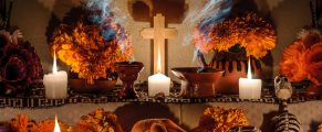 Bright altar with candles, marigolds, and traditional Mexican elements for Día de los Muertos celebration.