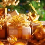 Gold Christmas presents with shiny ribbons and ornaments, festive holiday decor.