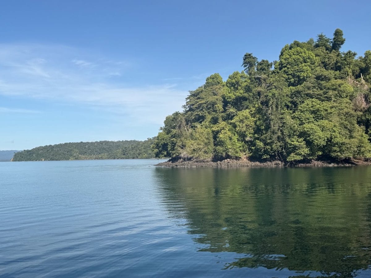 Adventure Cruising with Kontiki Expeditions in Costa Rica 5 Beautiful lake with calm water and lush green hills under a clear blue sky.