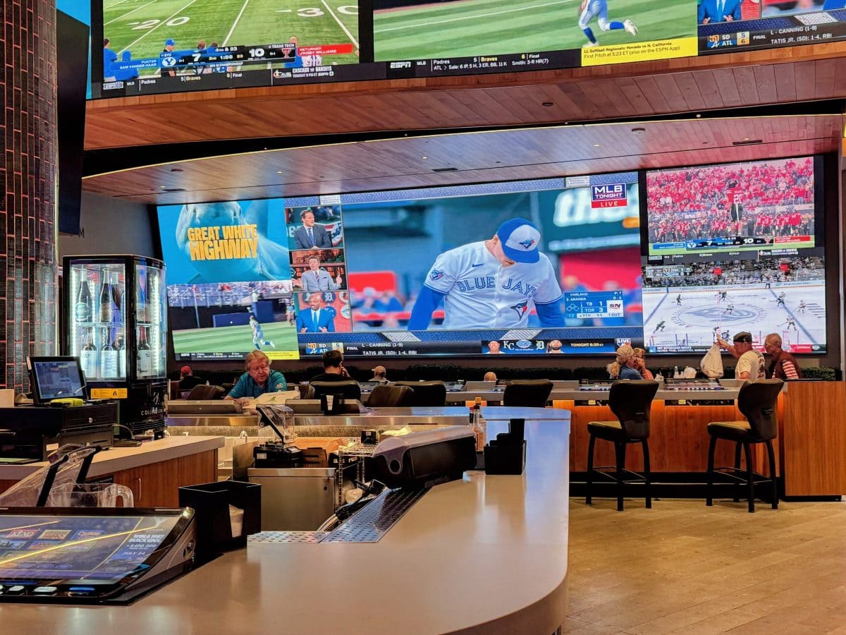 Sports bar with multiple large TV screens showing baseball and football games.